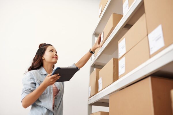 mulher-usando-tablet-para-organizar-caixas-em-estoque